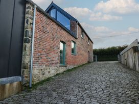 An outdoor area with a brick wall and a cobblestone path at The Barn in Newport