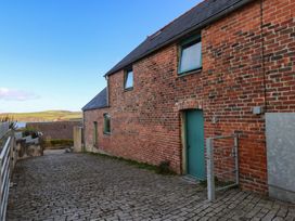 An exterior view of a brick building with paved path at The Barn in Newport