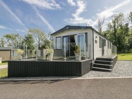 A mobile home with a deck and planters at Grasmoor View Lodge