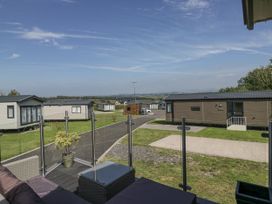 An outdoor area with holiday homes and a pathway at Grasmoor View Lodge in 