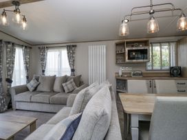 A living room with sofas and a dining area at Grasmoor View Lodge
