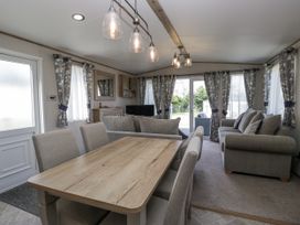 A living room with a dining area and a sofa at Grasmoor View Lodge