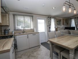 A kitchen with dining area and appliances at Grasmoor View Lodge