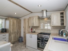 A kitchen with cabinets and appliances at Grasmoor View Lodge