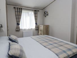 A bedroom with a bed and window at Grasmoor View Lodge