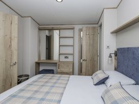 A bedroom with a bed and dressing table at Grasmoor View Lodge
