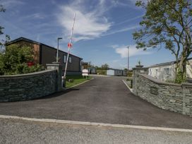 A stone wall with a gate and mobile homes at Grasmoor View Lodge
