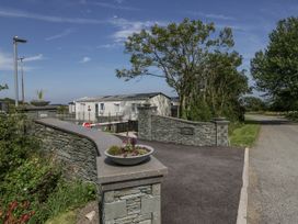 An outdoor entrance with a stone wall and caravan at Grasmoor View Lodge