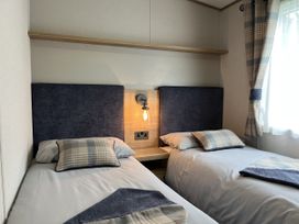 A bedroom with two beds and a light fixture at Winscales Rest in Winscales