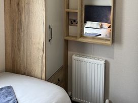 A bedroom with a bed and wardrobe at Winscales Rest in Winscales