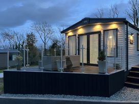 A mobile home with a deck and glass railing at Winscales Rest in Winscales