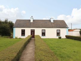 A house with a pathway and hedges at The Farmhouse in Tralee, County Kerry