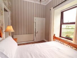 A bedroom with a bed and window at The Farmhouse in Tralee, County Kerry