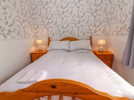 A bedroom with a bed and bedside tables at The Farmhouse in Tralee, County Kerry