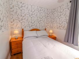 A bedroom with a bed and nightstands at The Farmhouse in Tralee, County Kerry