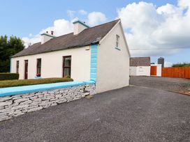 A house with a stone wall and gravel driveway at The Farmhouse in Tralee, County Kerry