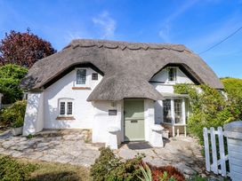 A cottage with thatched roof and garden at Smugglers Cottage in New Milton