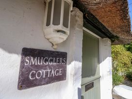 A sign with the name Smugglers Cottage at Smugglers Cottage in New Milton