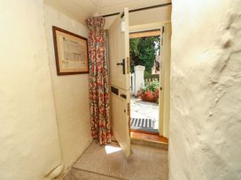 A hallway with an open door and a curtain at Smugglers Cottage in New Milton
