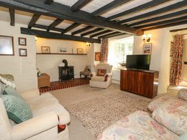 A living room with a fireplace and television at Smugglers Cottage in New Milton