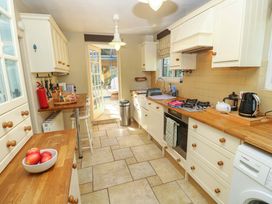 A kitchen with appliances and a view of the garden at Smugglers Cottage in New Milton