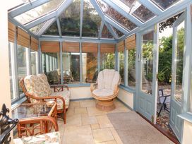 A conservatory with seating and windows at Smugglers Cottage in New Milton