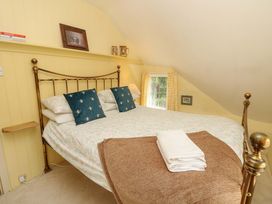 A bedroom with a bed and shelves at Smugglers Cottage in New Milton
