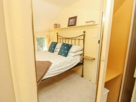A bedroom with a bed and window at Smugglers Cottage in New Milton