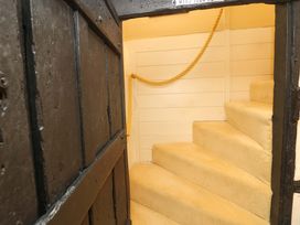 A staircase with carpeted steps and a door at Smugglers Cottage in New Milton
