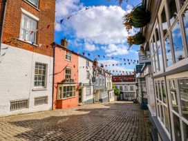 A street with buildings and bunting at Smugglers Cottage in New Milton