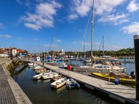 A marina with boats and a dock at Smugglers Cottage in New Milton