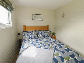 A bedroom with a bed and bedside table at Seiriol Shepherds hut in Ty Croes
