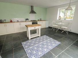 A kitchen with a stove and refrigerator at Seiriol Shepherds hut Ty Croes