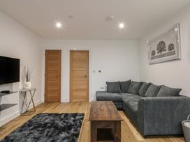 A living room with a sofa and television at 2 Harbour Lights Cemaes Bay