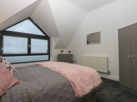 A bedroom with a bed and window at 2 Harbour Lights Cemaes Bay