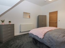 A bedroom with a bed and dresser at 2 Harbour Lights Cemaes Bay