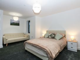 A bedroom with a bed, couch and lamps at 2 Harbour Lights in Cemaes Bay