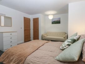 A bedroom with a bed and sofa at 2 Harbour Lights Cemaes Bay