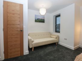 A living room with a sofa and a window at 2 Harbour Lights Cemaes Bay