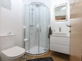 A bathroom with a shower, toilet, and washbasin at 2 Harbour Lights Cemaes Bay