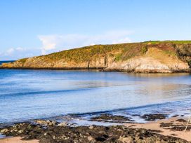 A coastal view with water and rocks at 2 Harbour Lights Cemaes Bay