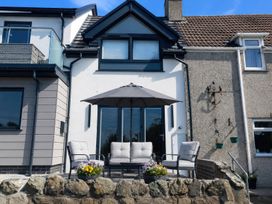 An outdoor seating area with chairs and table at 2 Harbour Lights Cemaes Bay