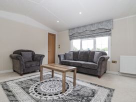 A living room with a sofa and armchair in The Cabin Thornton Dale