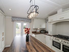 A kitchen with a gas stove and microwave at The Cabin in Thornton Dale