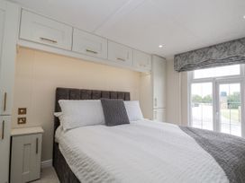 A bedroom with a bed and cabinets at The Cabin in Thornton Dale