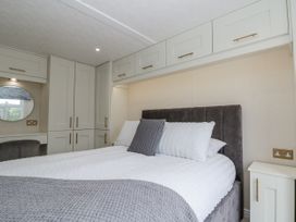 A bedroom with a bed and storage cabinets at The Cabin in Thornton Dale