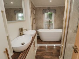 A bathroom with a bathtub and two sinks at The Cabin in Thornton Dale
