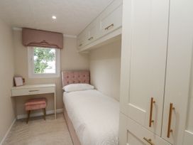 A bedroom with a bed, desk, and wardrobe at The Cabin in Thornton Dale