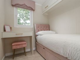 A bedroom with a bed and a desk at The Cabin in Thornton Dale