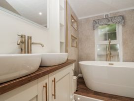 A bathroom with a washbasin and a bathtub at The Cabin in Thornton Dale